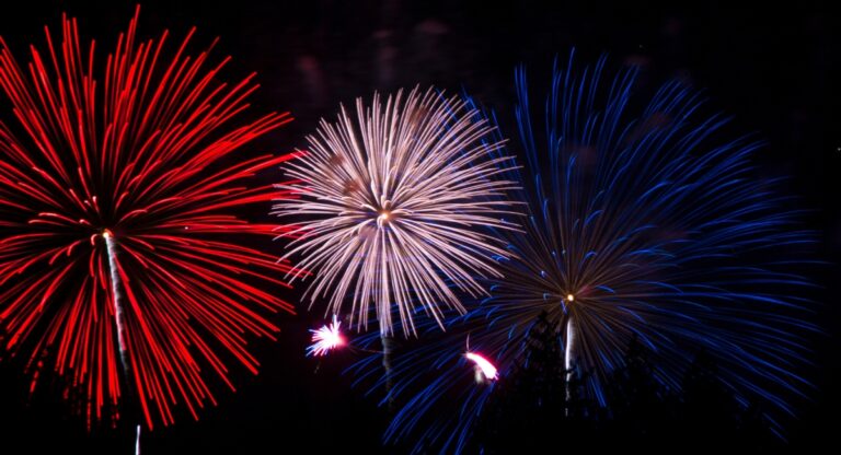 three fireworks in the sky - one is red, one is white, one is blue
